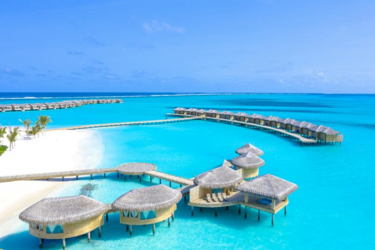 Stunning aerial view of tropical overwater bungalows on the clear blue waters of the Maldives.